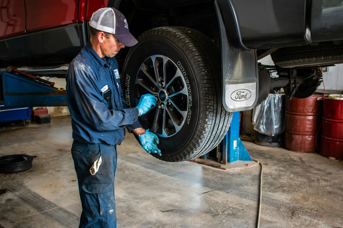 A technician fitting a wheel on a Ford