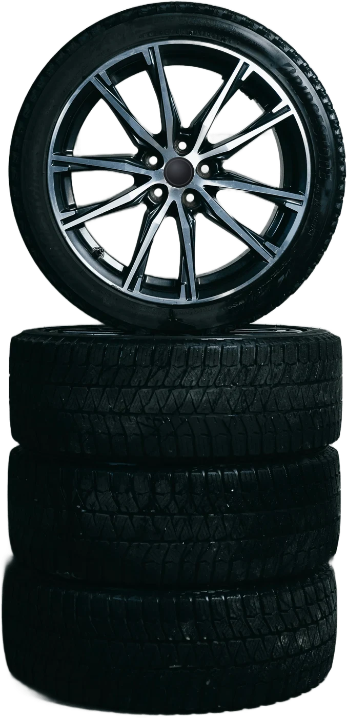 A stack of winter tires with an alloy wheel on top